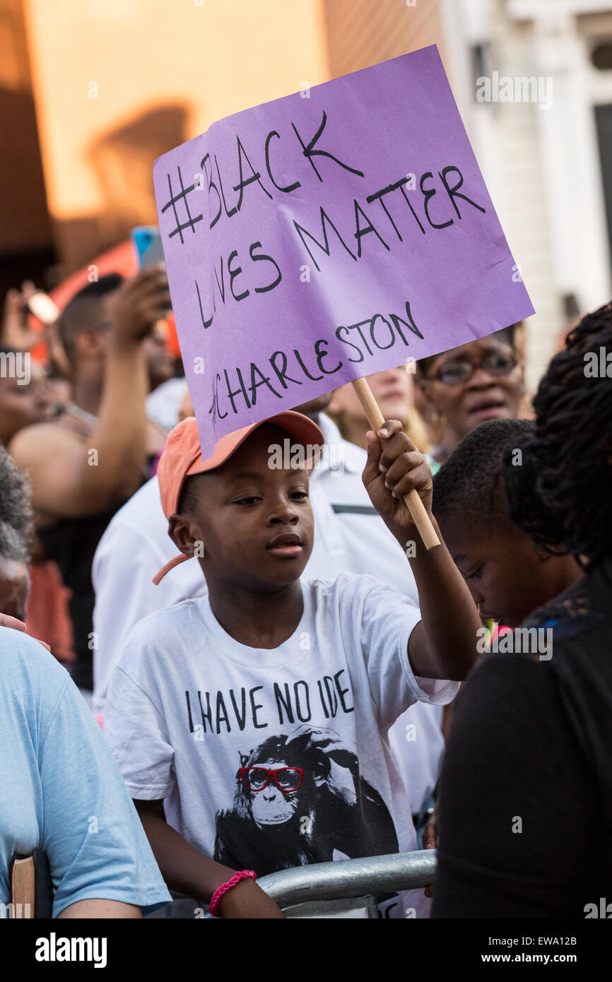 Un mourner detiene un segno a un memoriale di fortuna al di fuori della storica madre Emanuel metodista africana Chiesa Episcopale Giugno 20, 2015 a Charleston, Carolina del Sud. In precedenza durante la settimana una supremazia bianca pistolero ucciso 9 membri presso la storica chiesa nera. Foto Stock