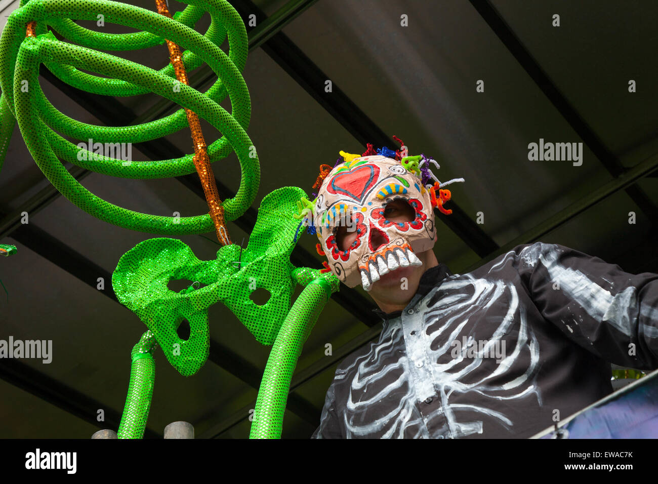Figura scheletrica verde e uomo mascherato con volto oscurato in abito elegante a Preston, Lancashire, UK Giugno 2015. Annuale Carnevale dei Caraibi. Preston celebra il Carnevale dei Caraibi del 41st una celebrazione della cultura caraibica, delle arti, del cibo, dello spettacolo e dello spettacolo. Il Carnevale è organizzato da un team di volontari, che lavorano instancabilmente durante tutto l'anno, organizzando l'evento che è la più grande e più lunga celebrazione culturale a Preston al di fuori della Gilda Preston. Foto Stock