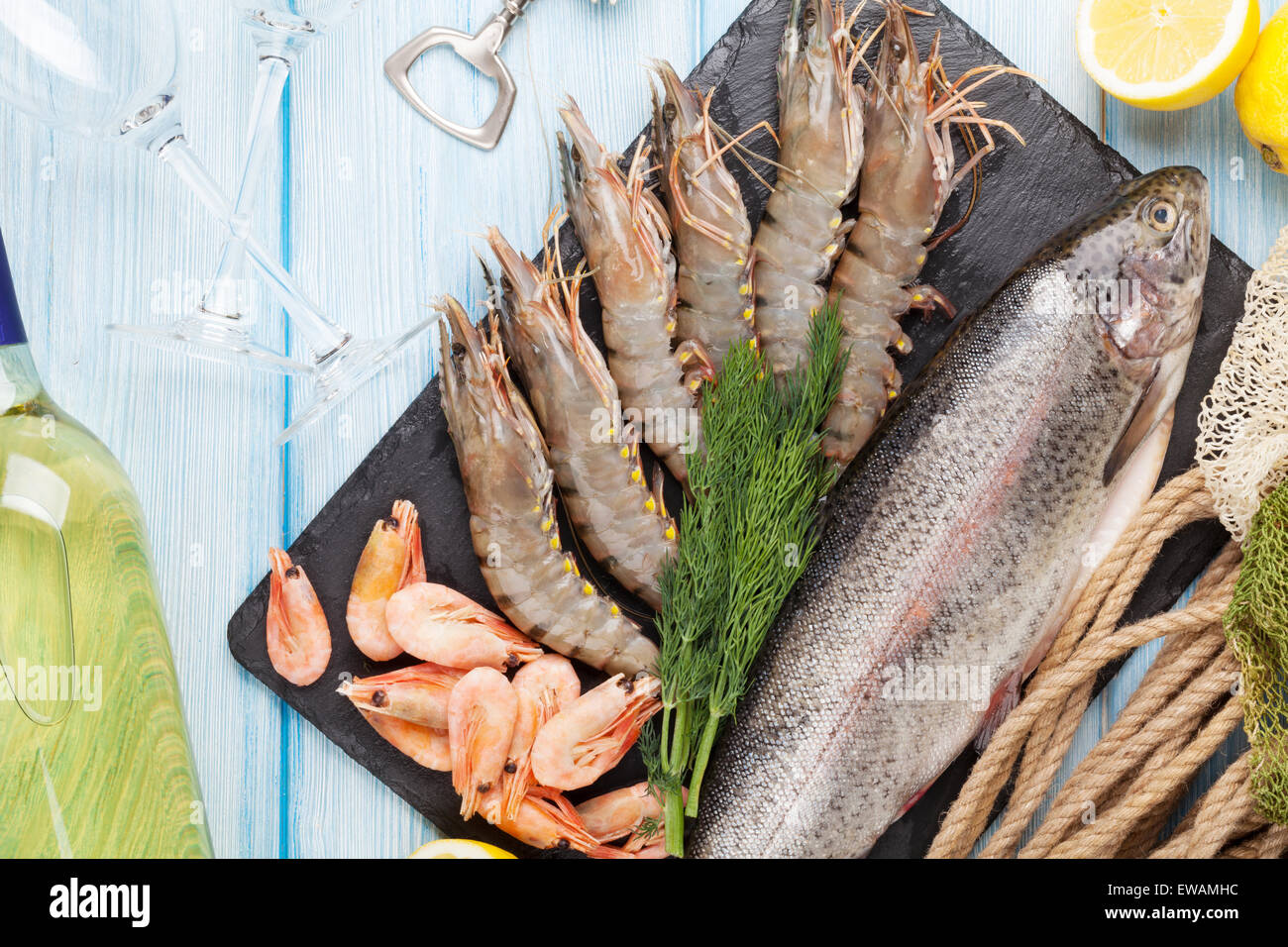 Crudo fresco il cibo del mare con spezie e vino bianco su tavola di legno dello sfondo. Vista superiore Foto Stock