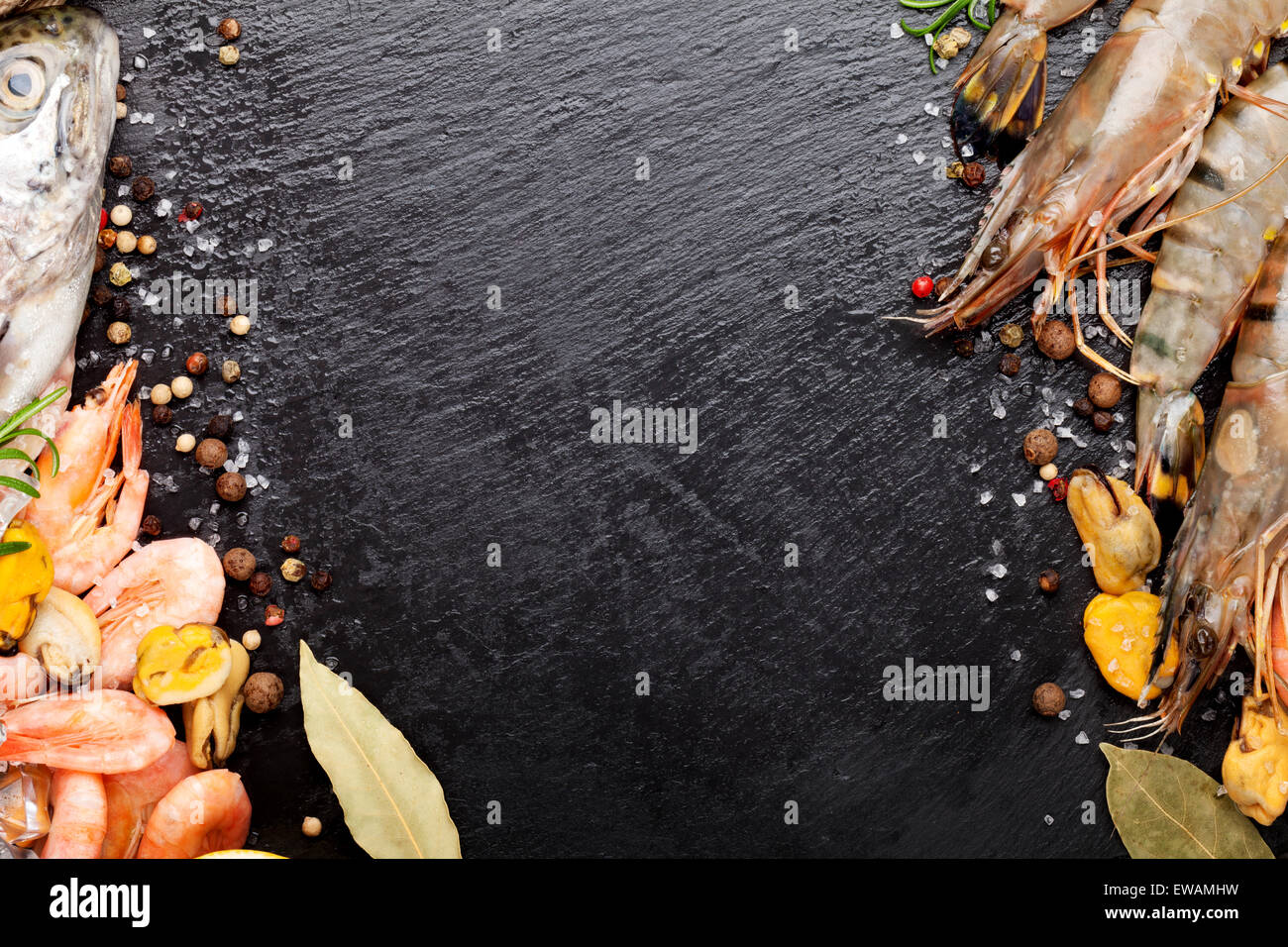 Crudo fresco il cibo del mare con spezie sulla pietra nera dello sfondo. Vista da sopra con lo spazio di copia Foto Stock