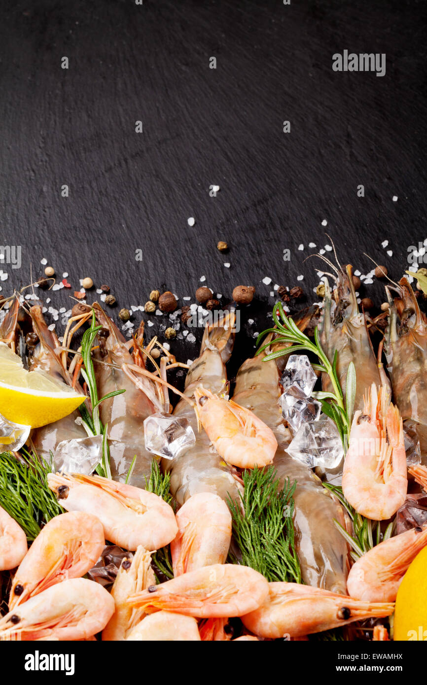 Gamberetti freschi con spezie sulla pietra nera dello sfondo. Vista da sopra con lo spazio di copia Foto Stock