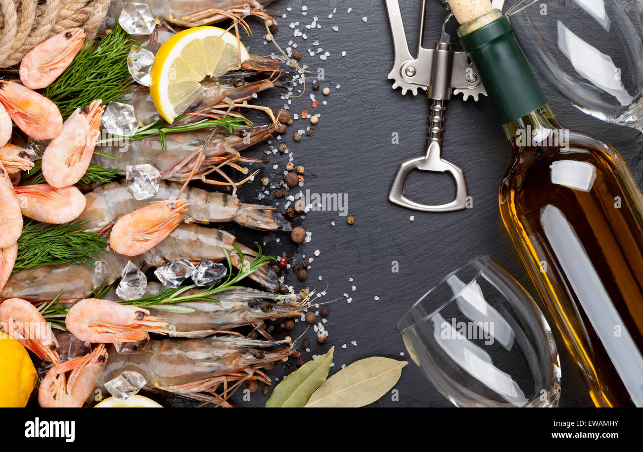 Gamberetti freschi con spezie e vino bianco su nero lo sfondo di pietra. Vista da sopra con lo spazio di copia Foto Stock