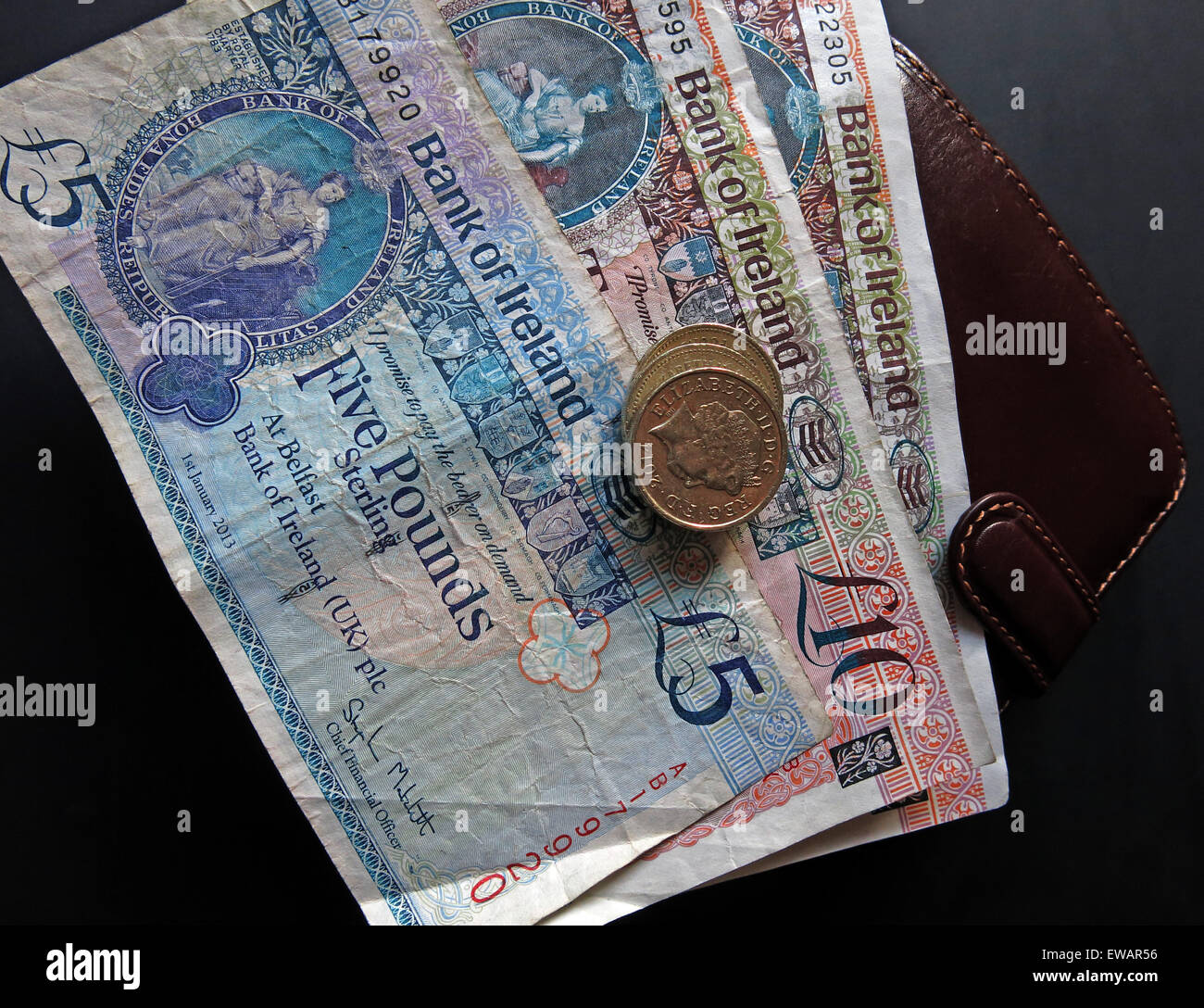 In Irlanda del Nord a 5 sterline, £10 note e cancelletto monete a corso legale della Banca di Irlanda Belfast, accanto un portafogli Foto Stock