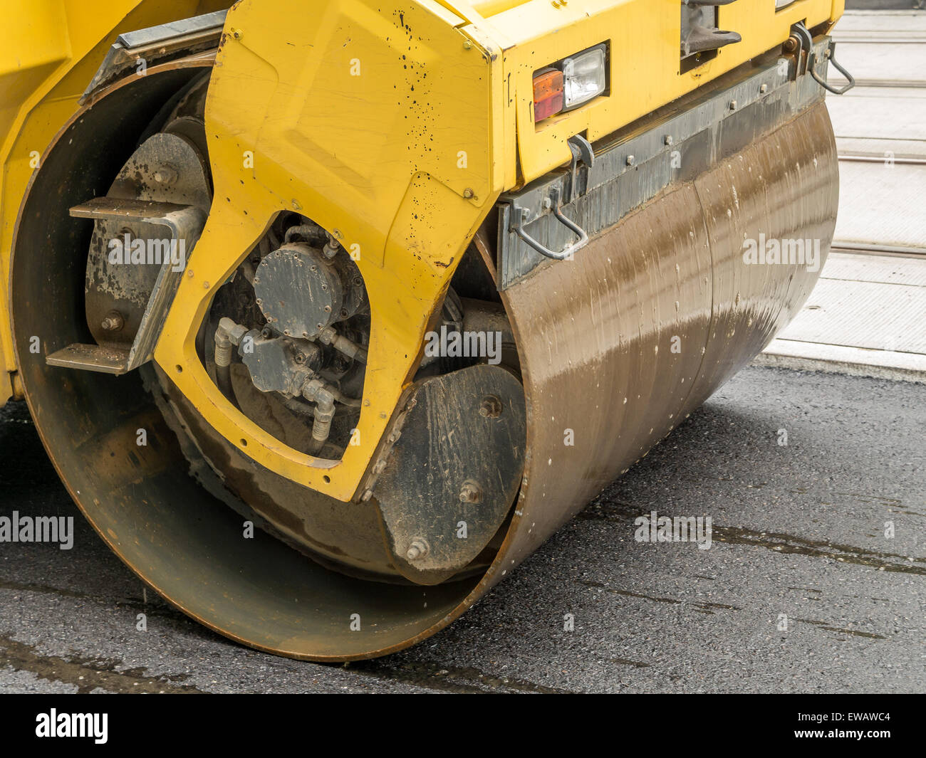 Vista dettagliata del giallo rullo stradale lisciatura freschi lo strato di asfalto Foto Stock