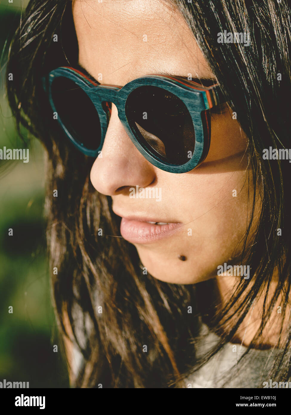 Brunette donna con occhiali da sole in una stretta su ritratto all'aperto Foto Stock