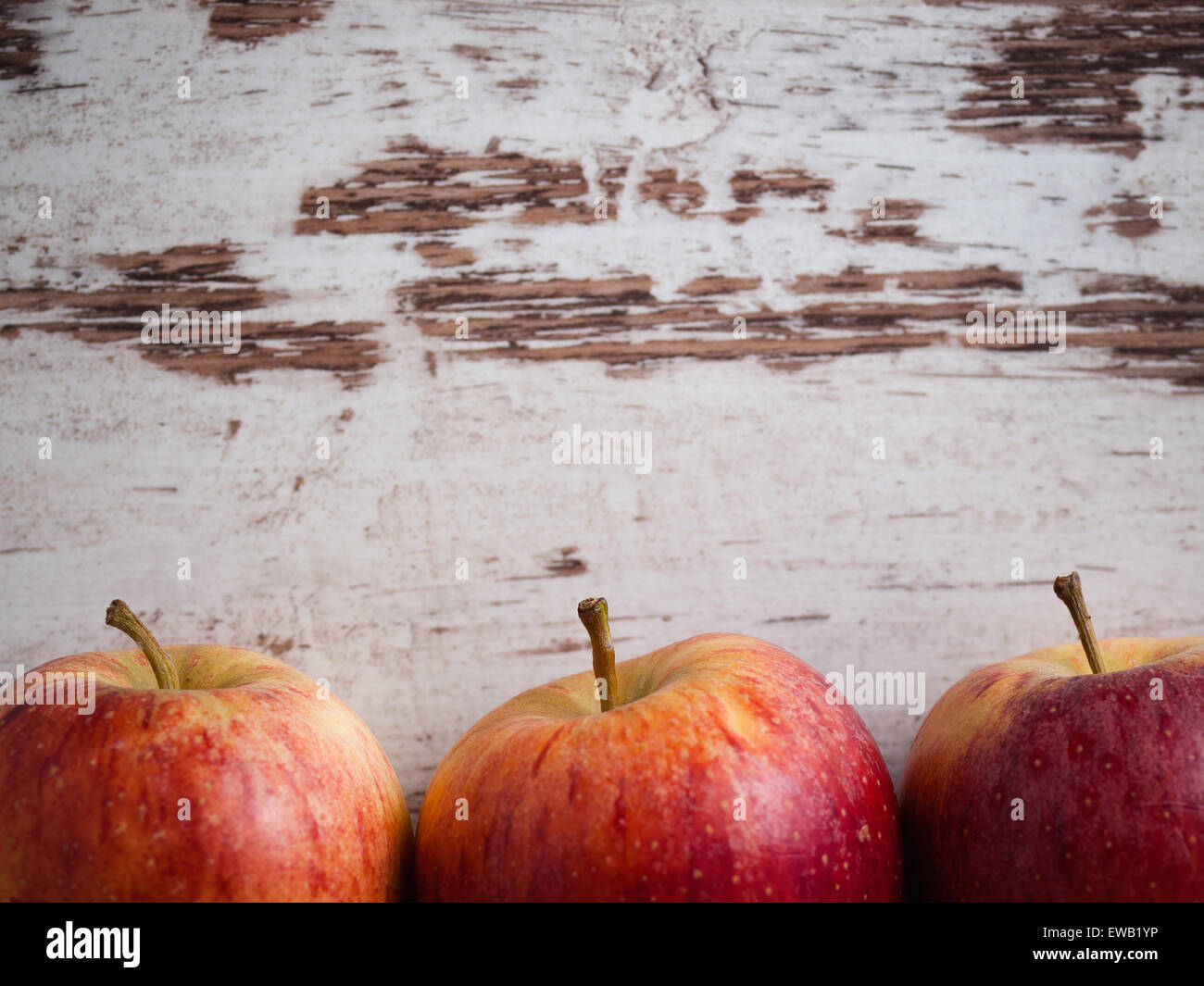 Tre Mele rosse su sfondo di legno in un background sani Foto Stock
