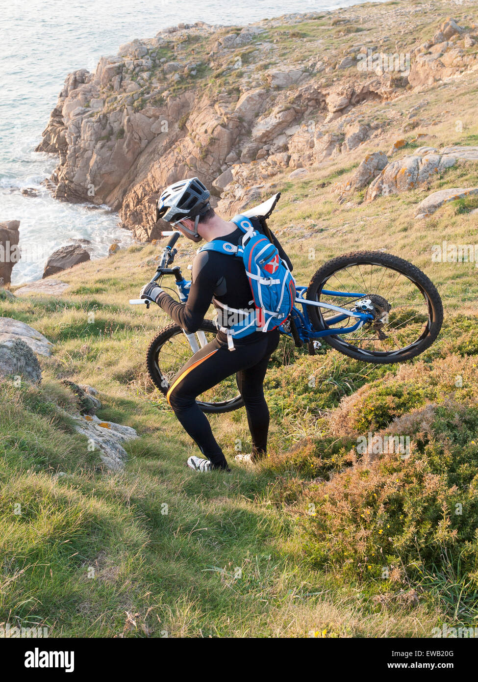 Ciclista portare la bici sulla costa della Galizia. L'uomo si trova in un ambiente piacevole e la pratica della mountain bike. Foto Stock