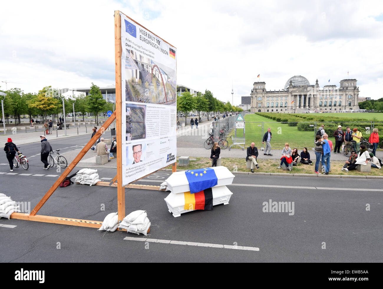 Una targhetta simbolica che recita "Qui l'Unione europea è costruita - i cimiteri - Gli immigrati sconosciuto' e due sarcofagi con il tedesco e la bandiera europea parallelamente alle azioni del centro di bellezza politico con lo slogan "Arco del determinato' presso il Bundestag tedesco a Berlino, Germania, 21 giugno 2015. Foto:RAINER JENSEN/dpa Foto Stock
