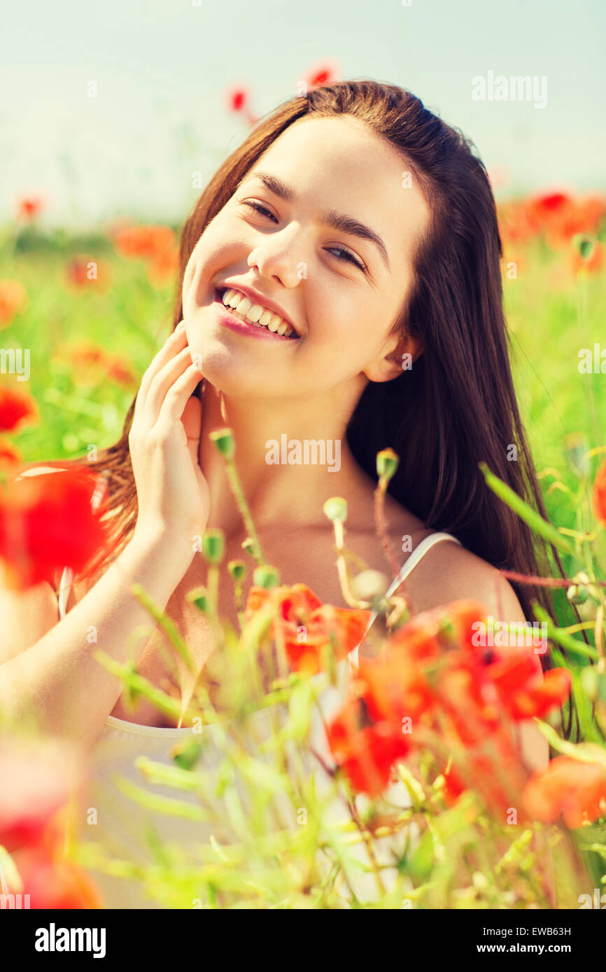 Sorridente giovane donna sul campo di papavero Foto Stock