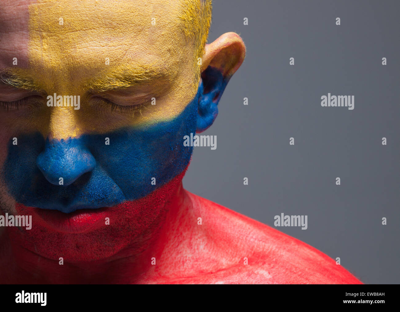 L uomo e il suo volto dipinto con la bandiera della Colombia. L'uomo ha gli occhi chiusi e composizione fotografica lascia solo metà del Foto Stock