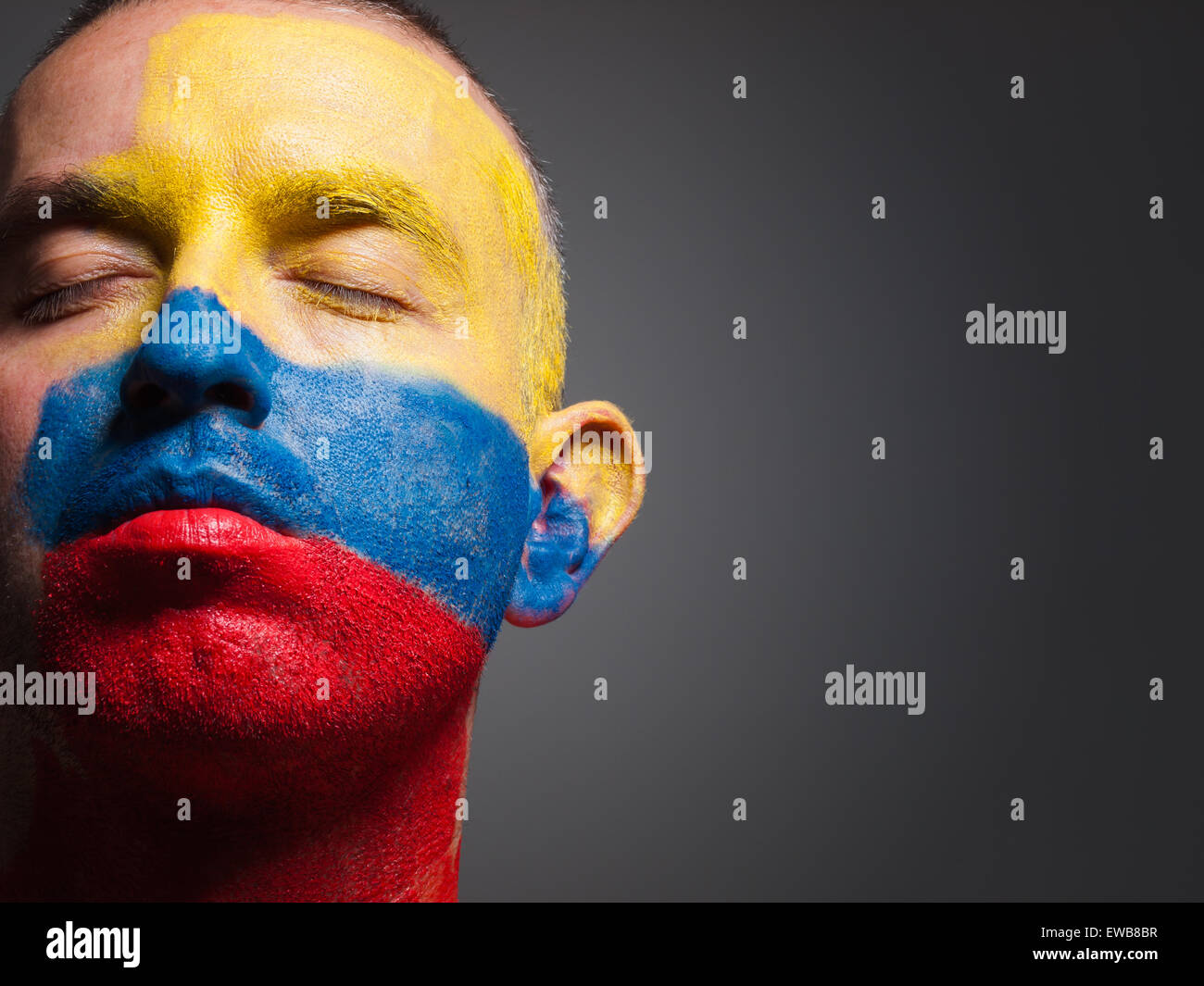 L uomo e il suo volto dipinto con la bandiera della Colombia. L'uomo ha gli occhi chiusi e composizione fotografica lascia solo metà del Foto Stock