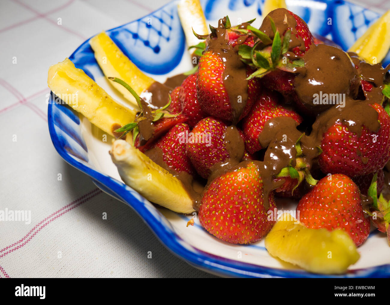 Banana e fragola sotto hot chodolate sulla tradizionale russo piastra - gzhel Foto Stock