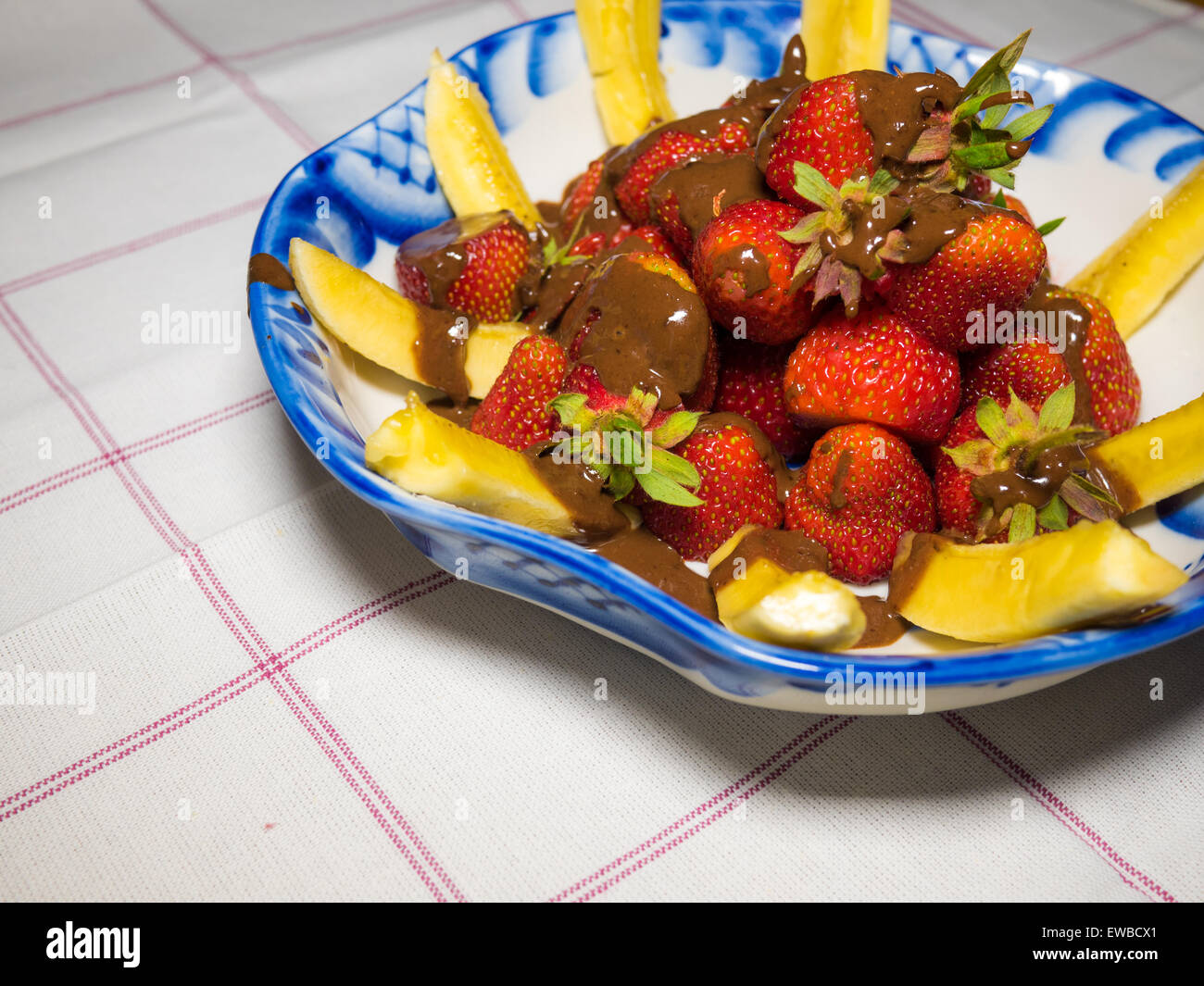 Banana e fragola sotto hot chodolate sulla tradizionale russo piastra - gzhel Foto Stock