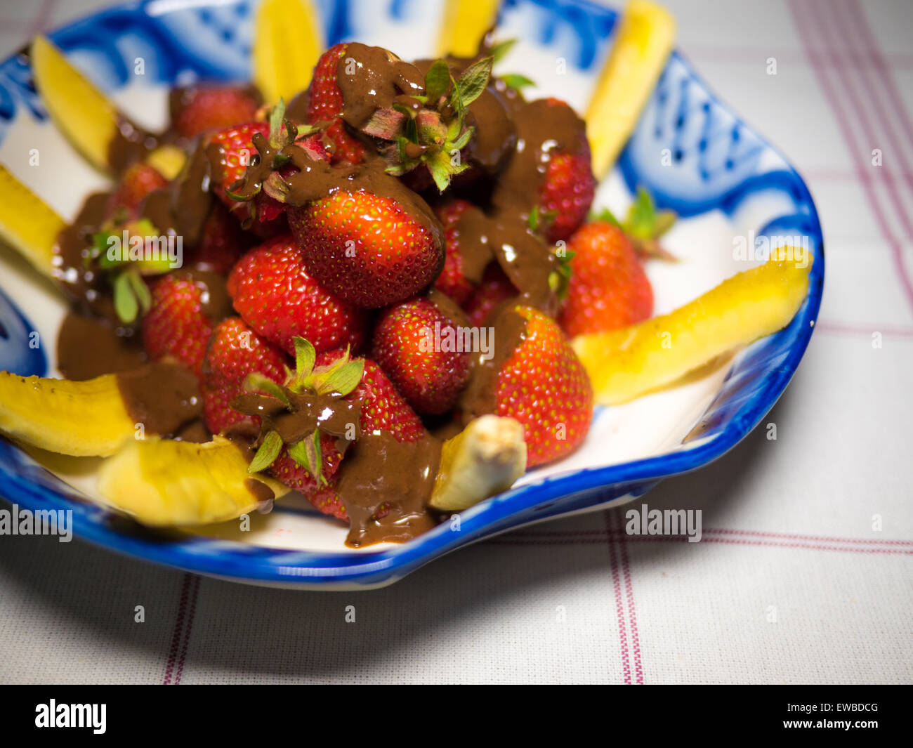 Banana e fragola sotto hot chodolate sulla tradizionale russo piastra - gzhel Foto Stock