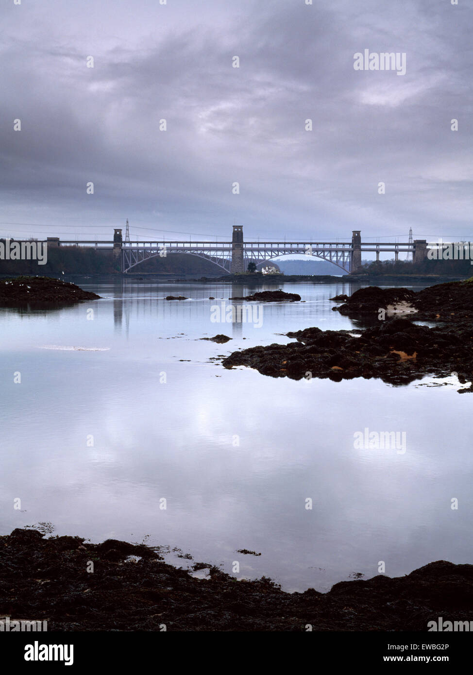 Britannia Bridge e dello Stretto di Menai dalla riva, St Tysilio's isola nei pressi di Menai Bridge Anglesey, Galles del Nord, Regno Unito Foto Stock