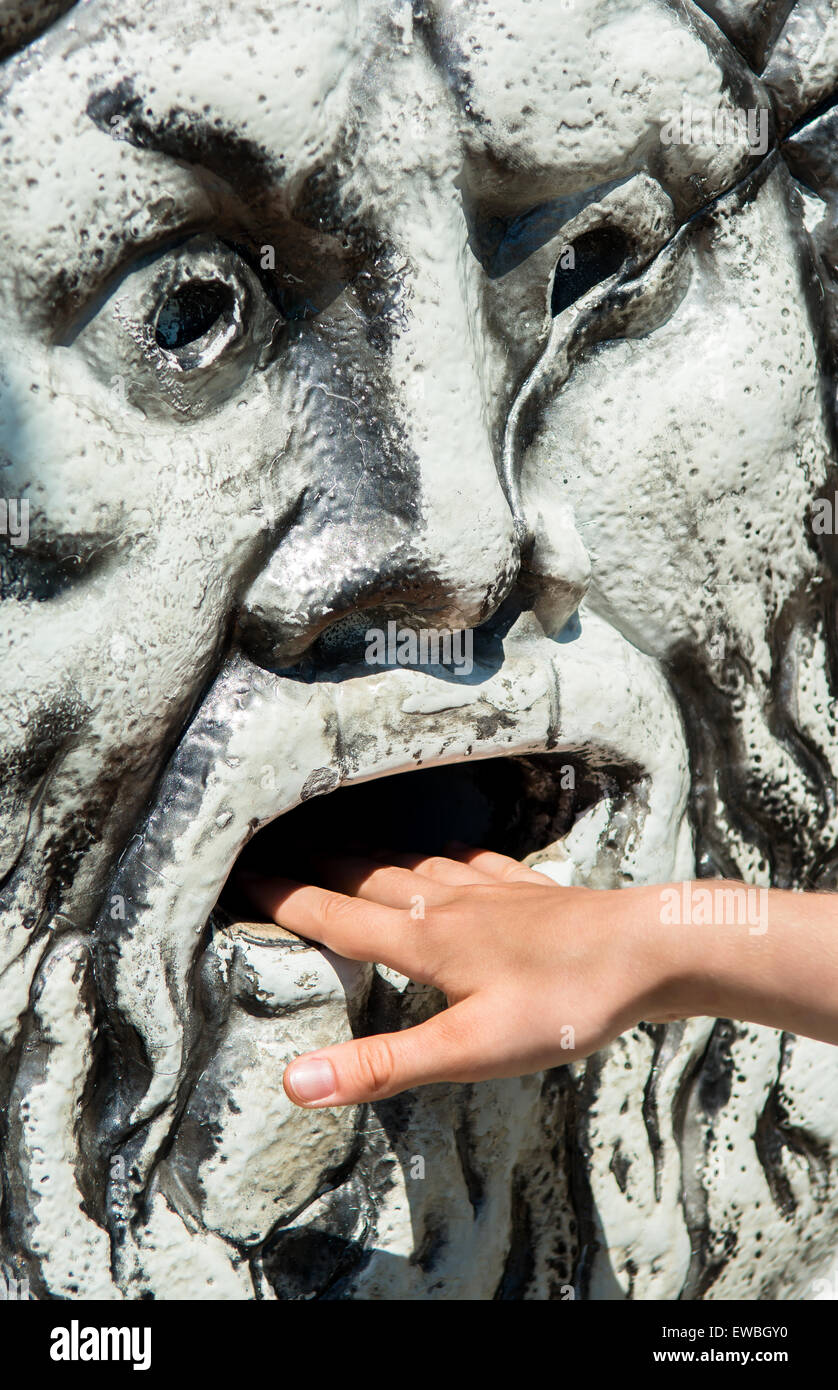 Faccia di pietra con mano in bocca Foto Stock