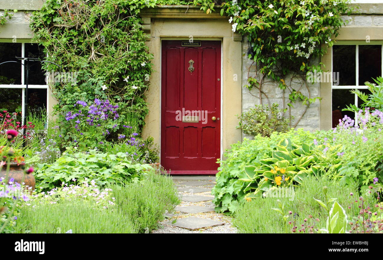 Un tradizionale cottage Inglese giardino incornicia il percorso di un cottage di campagna nel Parco Nazionale di Peak District, Inghilterra, Regno Unito estate Foto Stock