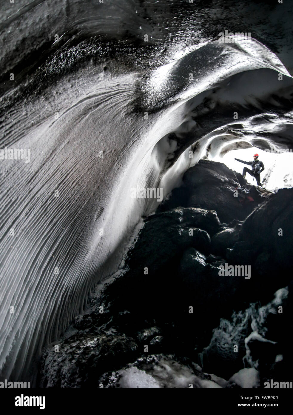 Un uomo si erge all'entrata di Warren grotta sul Monte Erebus, Antartide. Foto Stock