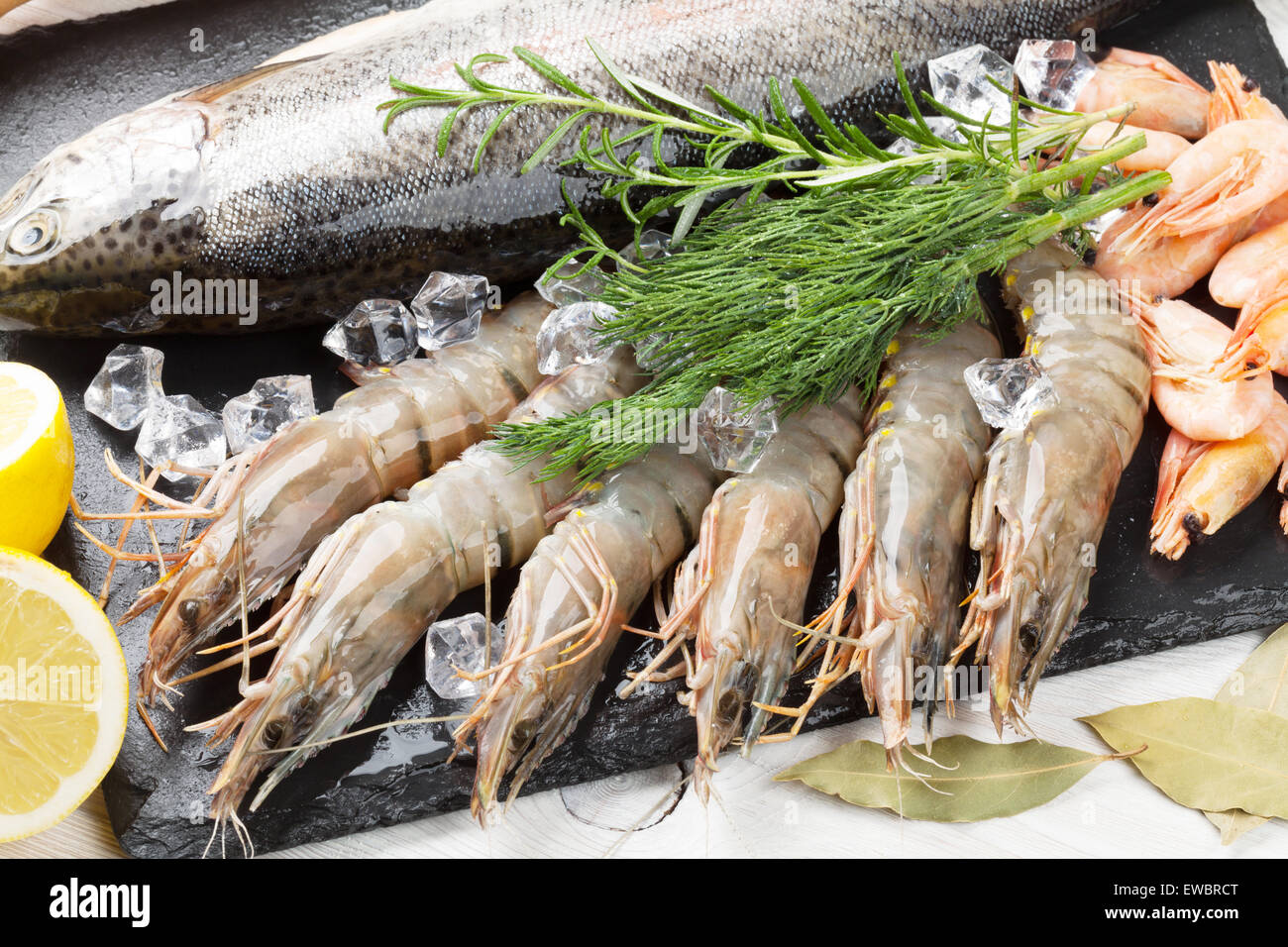 Crudo fresco il cibo del mare con spezie sulla lastra di pietra su un tavolo di legno dello sfondo. Vista superiore Foto Stock