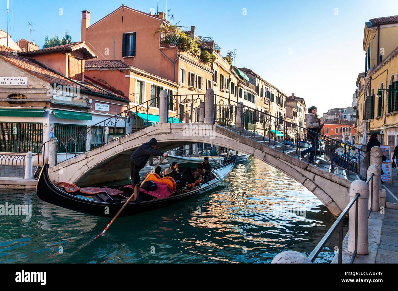 Gondola passa sotto un ponte su Fondamenta Minotto Canal a Venezia Italia Foto Stock