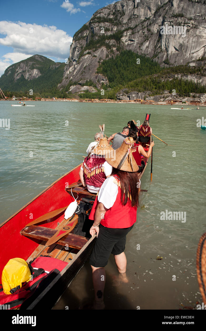 Squamish nazione dei rematori lanciare una tradizionale nativa la guerra in canoa lungo la Squamish waterfront. Squamish BC, Canada. Foto Stock
