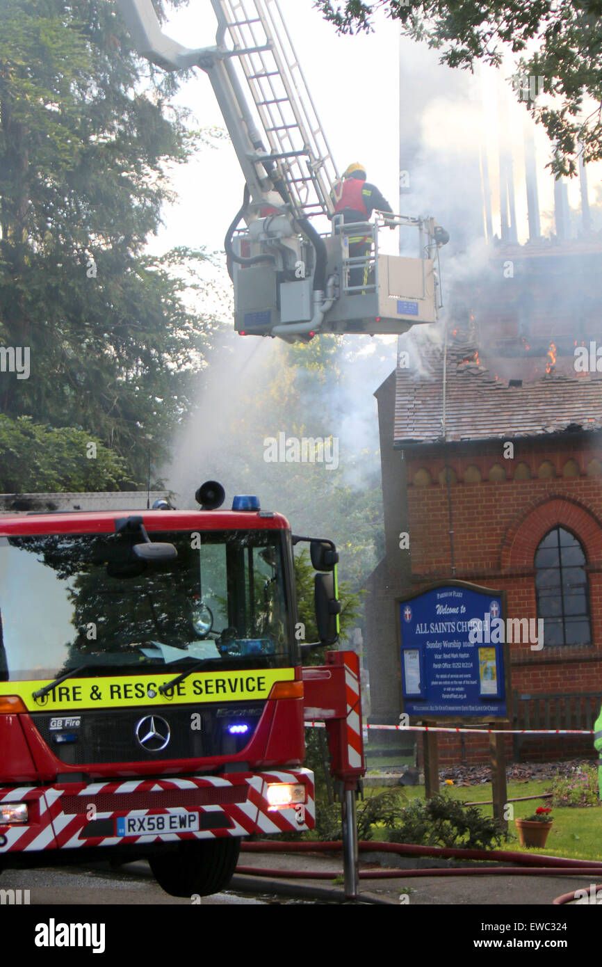 Fleet Hampshire, Regno Unito. Il 22 giugno, 2015. Quaranta figthers antincendio sono in lotta per il controllo di un incendio alla Chiesa di Tutti i Santi è stato distorey dal fuoco. Resident stanno venendo a patti con la perdita della comunità il mozzo. Un incendio doloso era già stata effettuata da una persona sconosciuta in precedenza nel corso della settimana è notevole a causa del suo architetto William Burges e è stato costruito 1861-2. Si tratta di una Grade II * listed building Credito: Jason Kay/Alamy Live News Foto Stock