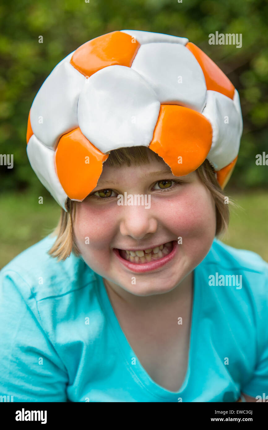 Giovane ragazza europea indossando il calcio in pelle sulla testa è ridere per la fotocamera Foto Stock