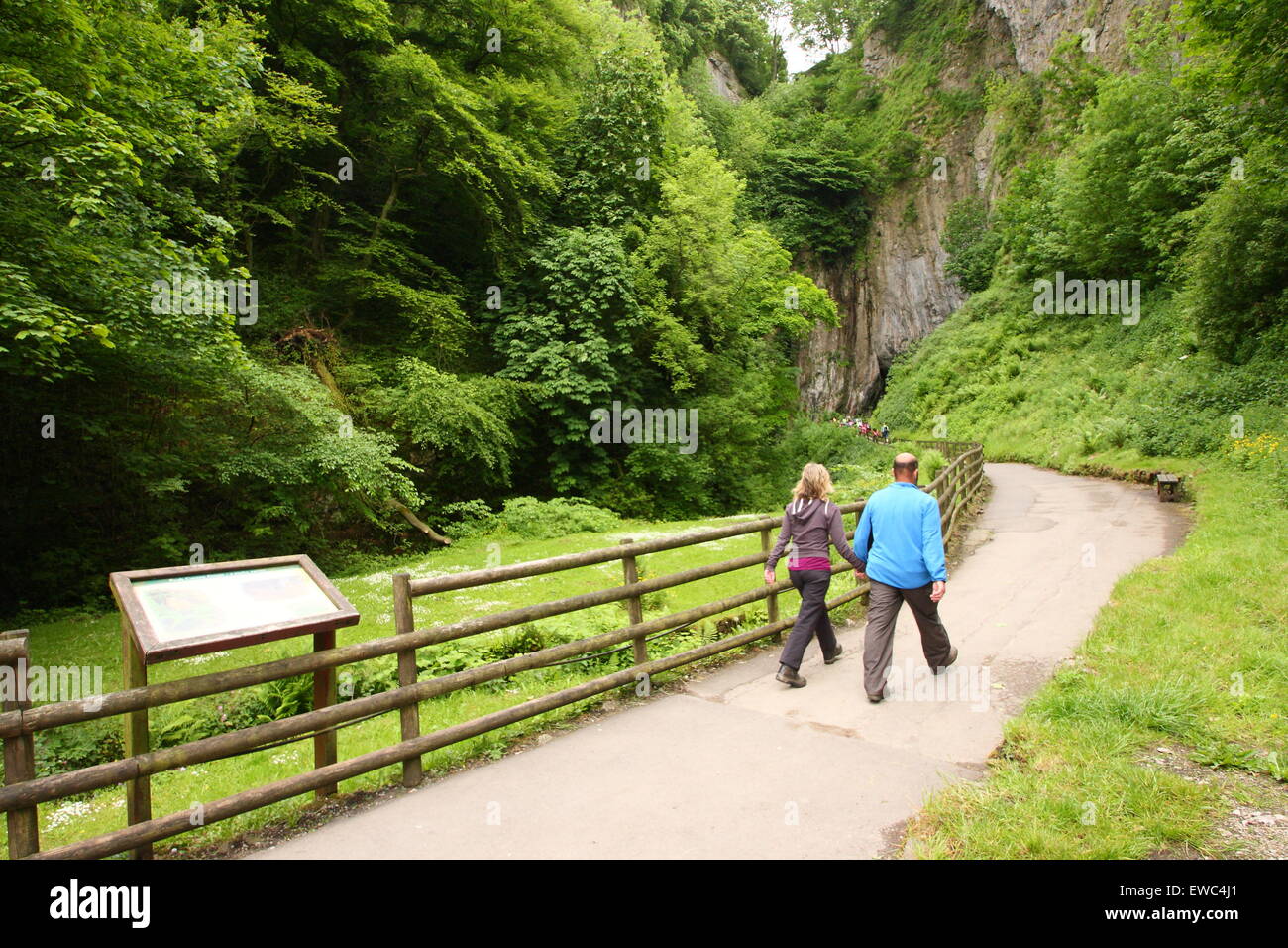 Le persone si avvicinano alla vasta entrata di Peak Cavern, mostrano una grotta in Castleton village, Peak District Derbyshire Regno Unito - estate Foto Stock