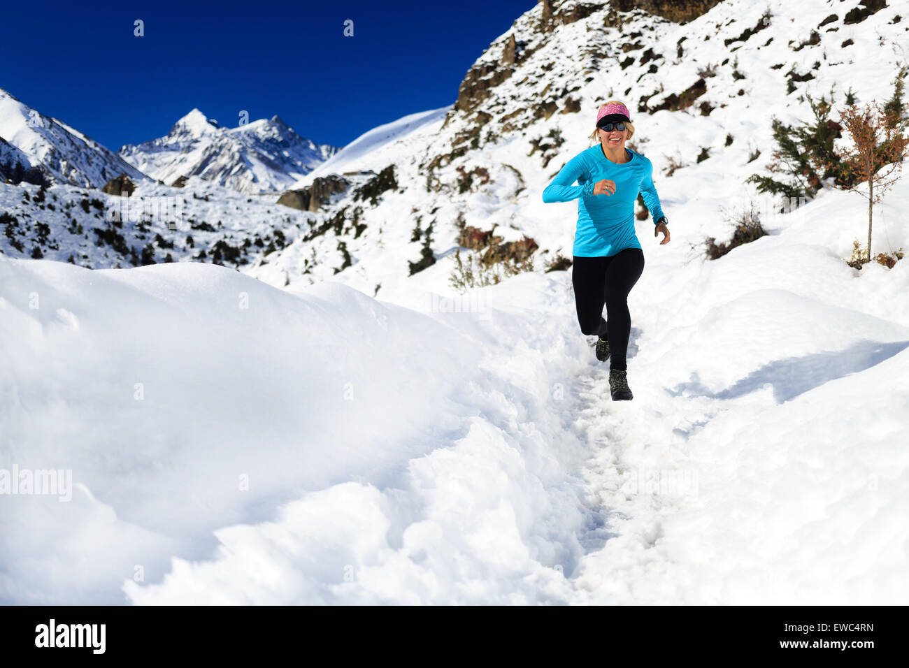 Donna felice cross country trail running in belle montagne ispiratrice del paesaggio. Uno stile di vita sano, fitness ed esercizio di unità organizzativa Foto Stock