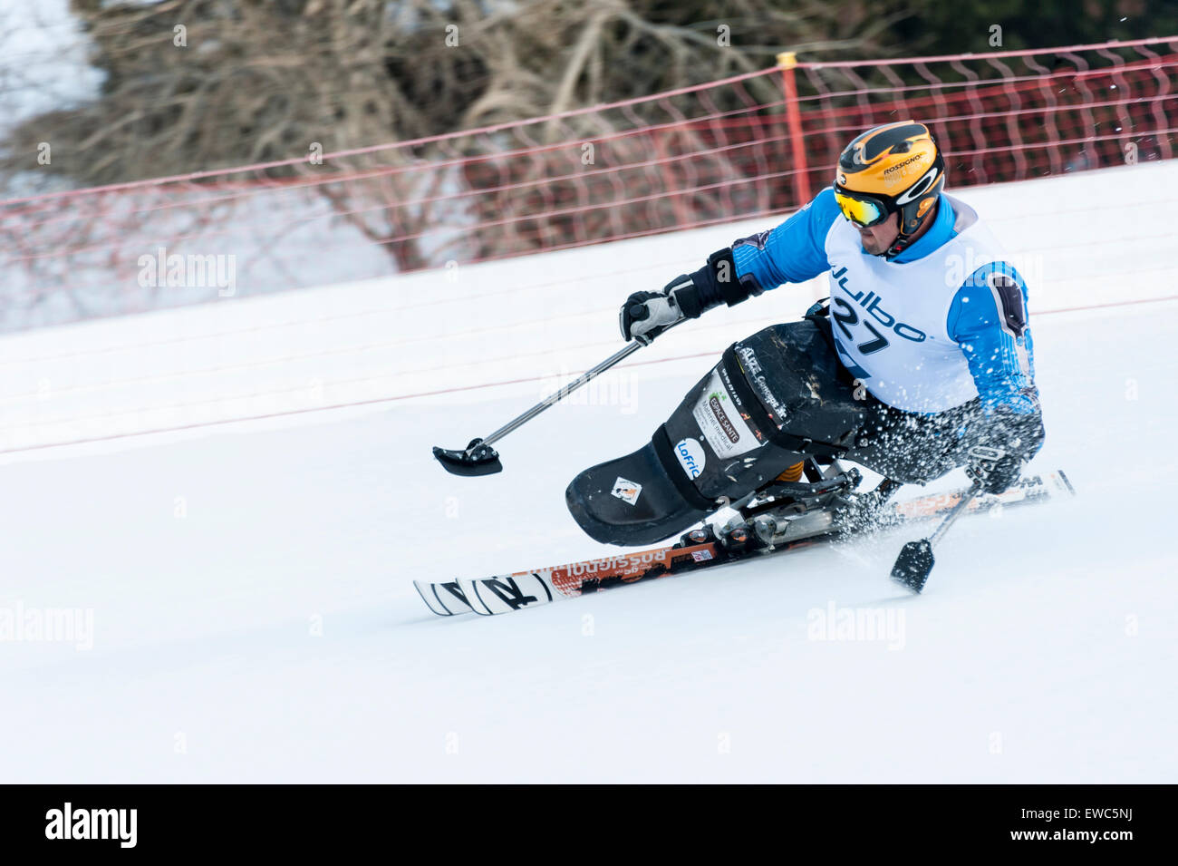 Un concorrente disabili utilizzando appositamente adattato attrezzatura da sci, corse in discesa in slalom gigante Foto Stock