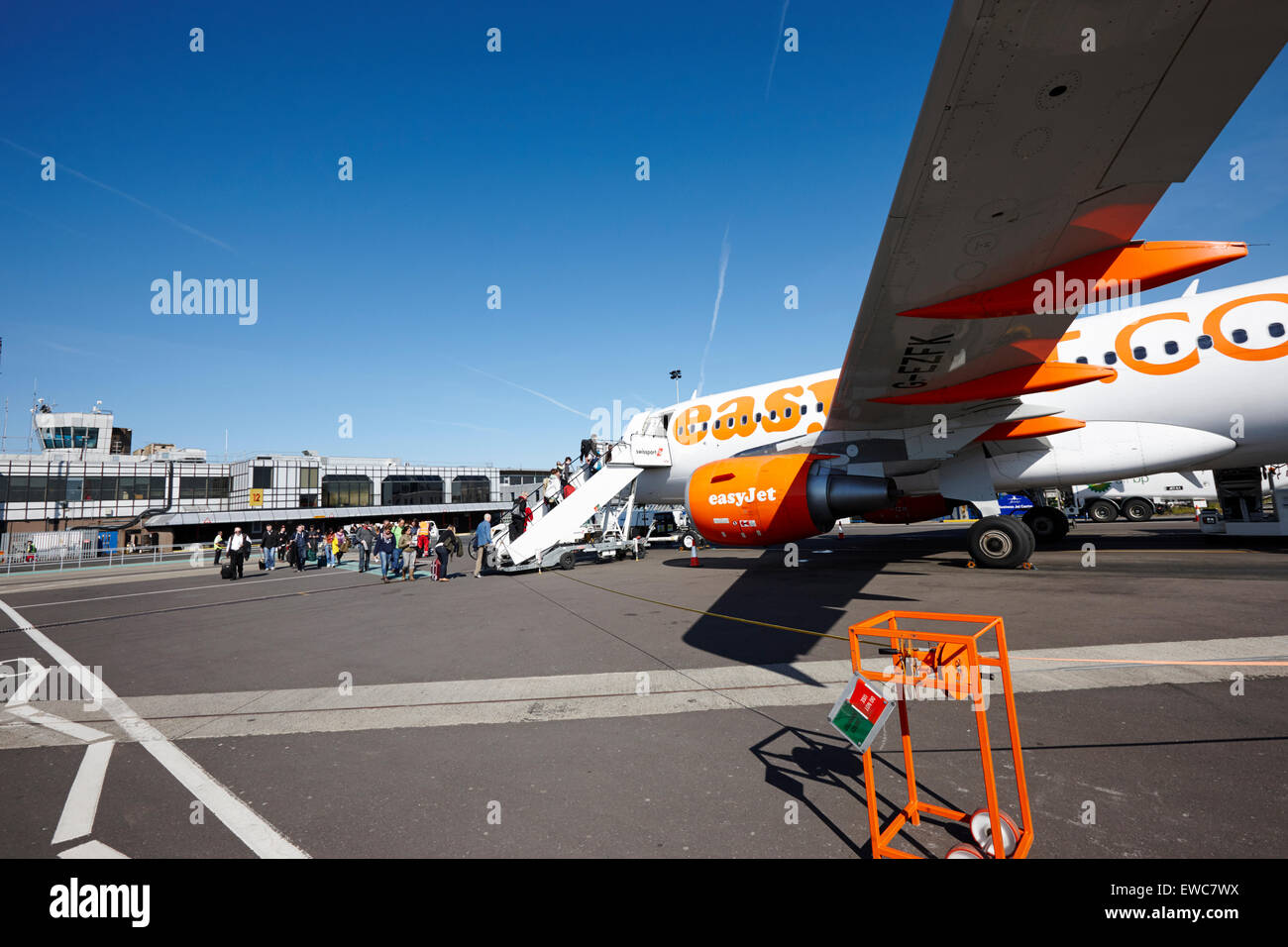 Camminando sotto l'ala di aeromobili easyjet come passeggeri l'Aeroporto Internazionale di Belfast Regno Unito Foto Stock