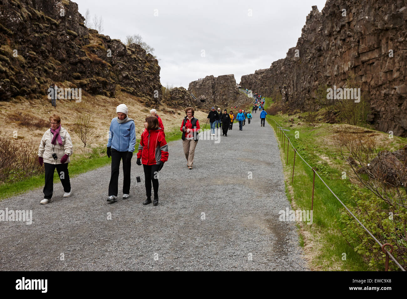 I turisti a piedi attraverso il Almannagja linea anomalia nel mid-atlantic ridge Nord America placca Thingvellir parco nazionale di Islanda Foto Stock