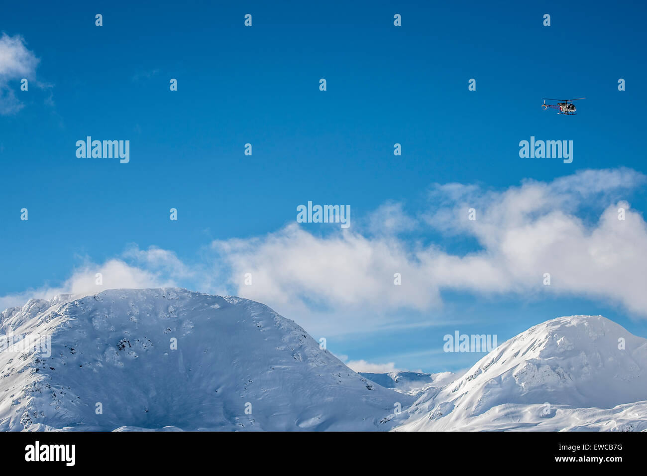 Un elicottero che vola alto sopra le montagne nevose in Simplonpass, Svizzera. Foto Stock