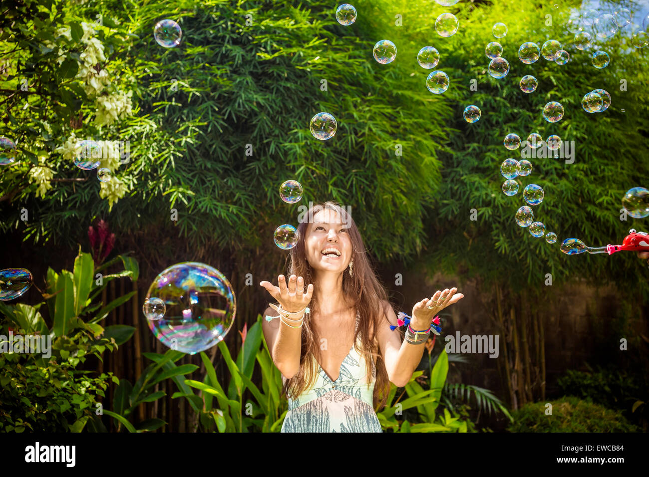 Giovani asiatici womans soffiare bolle. Foto Stock