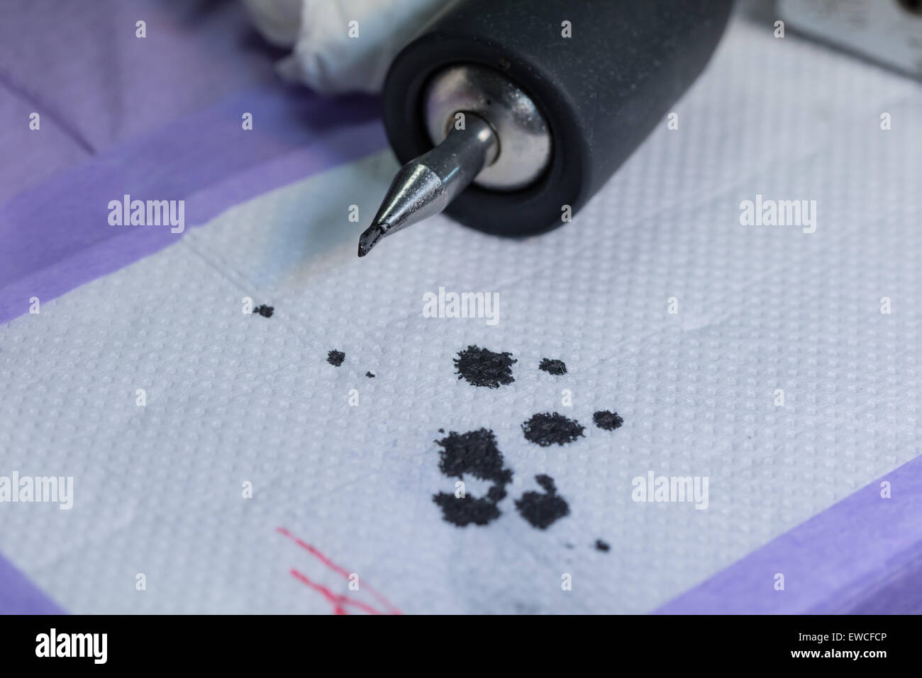 Un dermografo seduta sul tavolo di lavoro dopo aver terminato un tatuaggio, con inchiostro nero opener al di sotto di esso. Foto Stock