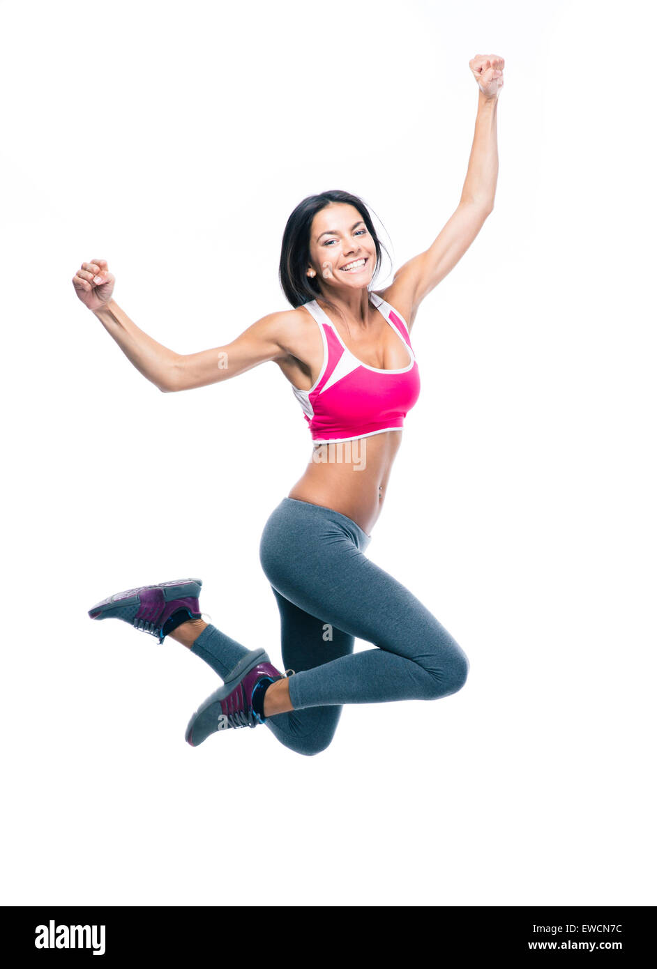 Felice donna sportivo jumping isolato su uno sfondo bianco. Guardando la fotocamera Foto Stock