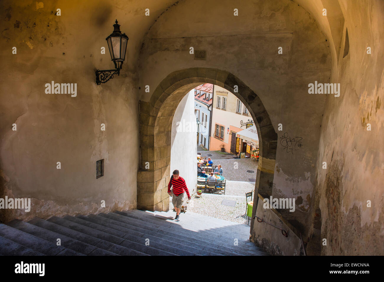 Vista di un uomo di entrare in un tipico porticato medioevale nel centro storico della cittadina Hradcany quartiere di Praga, Repubblica Ceca. Foto Stock