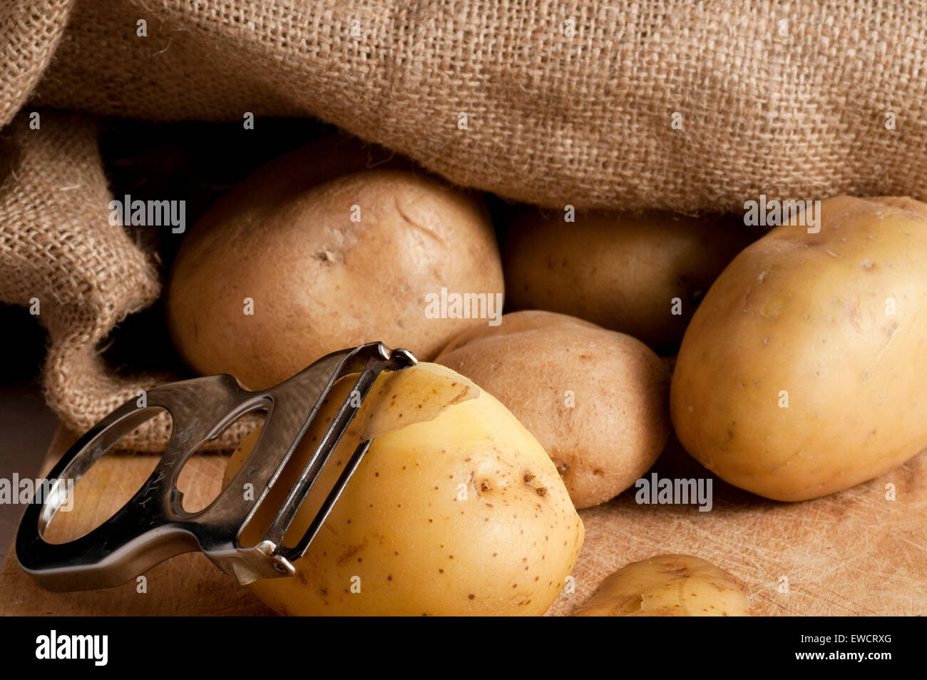 Patate al di fuori di un sacco di iuta Foto Stock