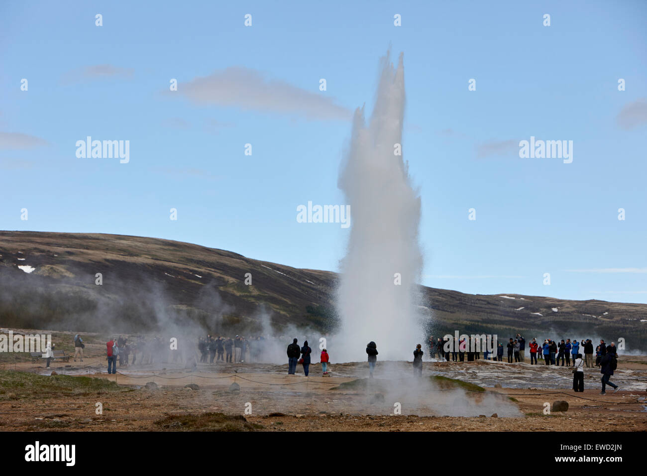 I turisti fotografare strokkur geyser che erutta a geyser sito geotermico Geysir Islanda Foto Stock
