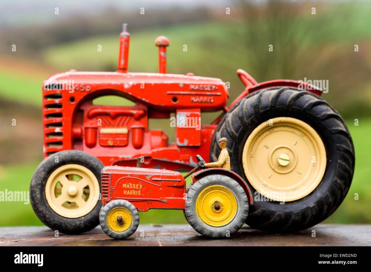 I giocattoli del trattore modello Dinky si fondono sullo sfondo di una campagna rurale Foto Stock