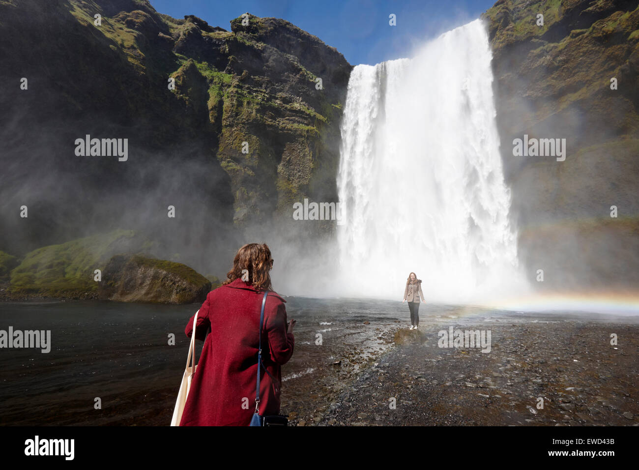 Due turisti femmina posa per fotografie a cascata skogafoss in Islanda Foto Stock