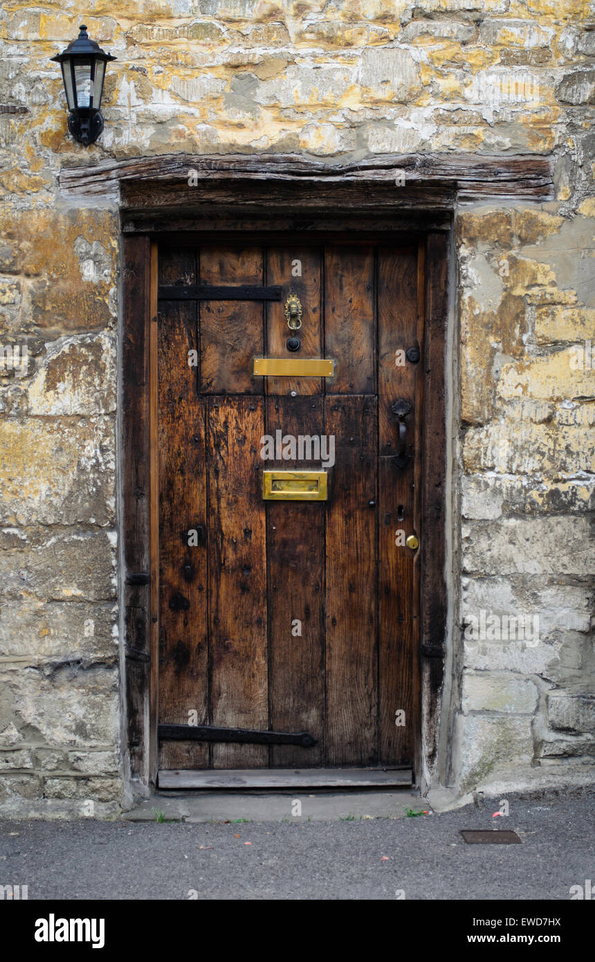 Vecchia porta di legno in un Cotswold stone house in Cotswolds, Inghilterra, Regno Unito. Foto Stock
