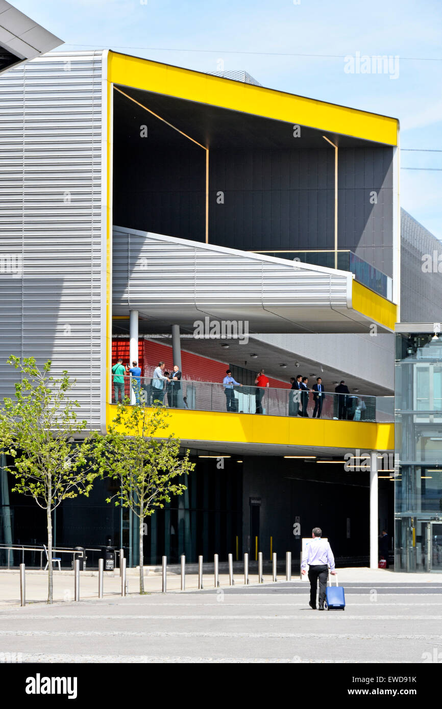 Business uomo a camminare verso la sala delle esposizioni ingresso orientale di Londra Excel Centre in East London Docklands Newham Regno Unito Inghilterra Foto Stock