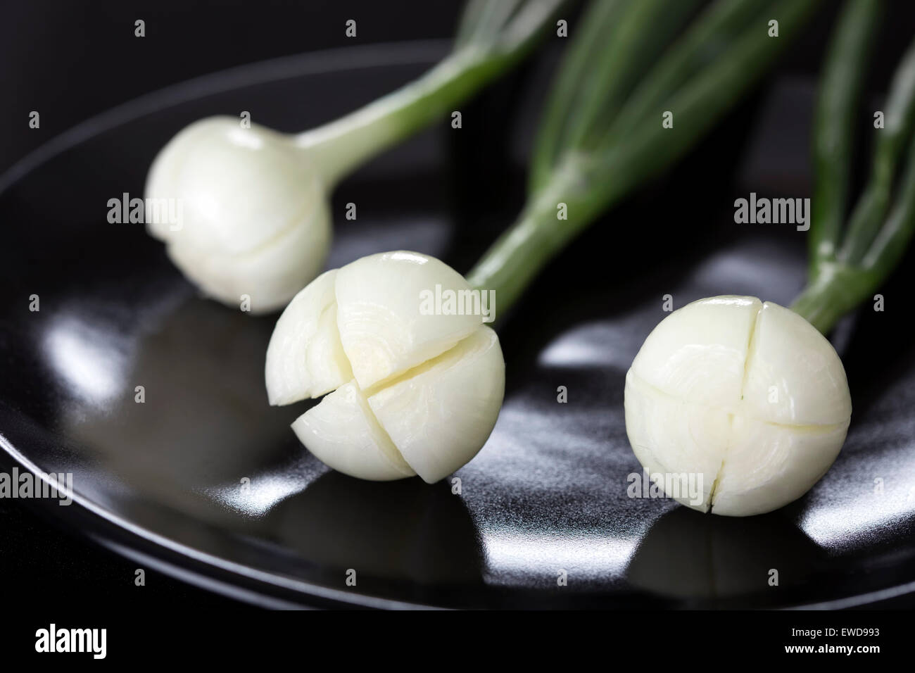 Fresca giovani onion sulla piastra scuro Foto Stock