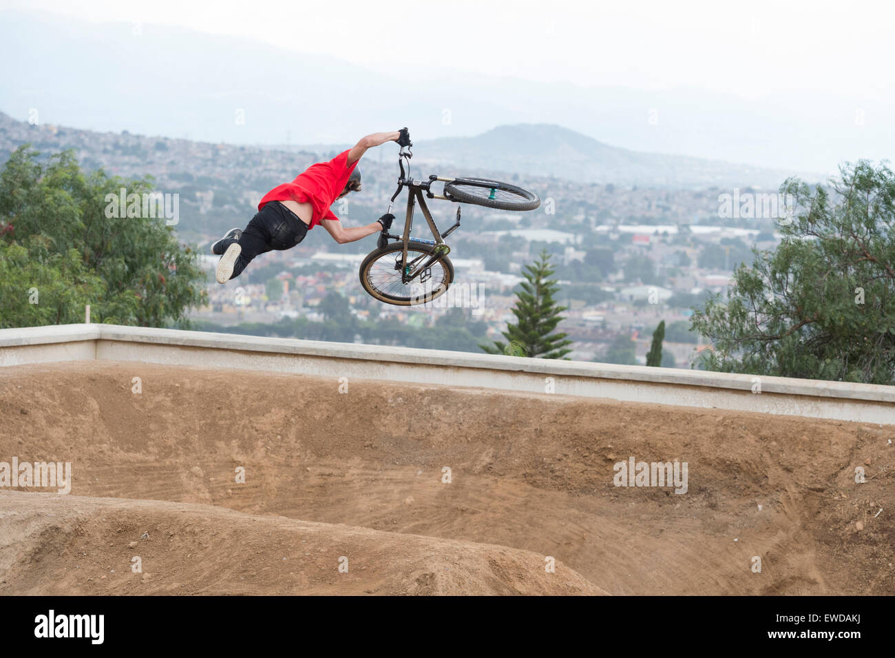 Mountain Biker salta sopra una pista sterrata. Foto Stock