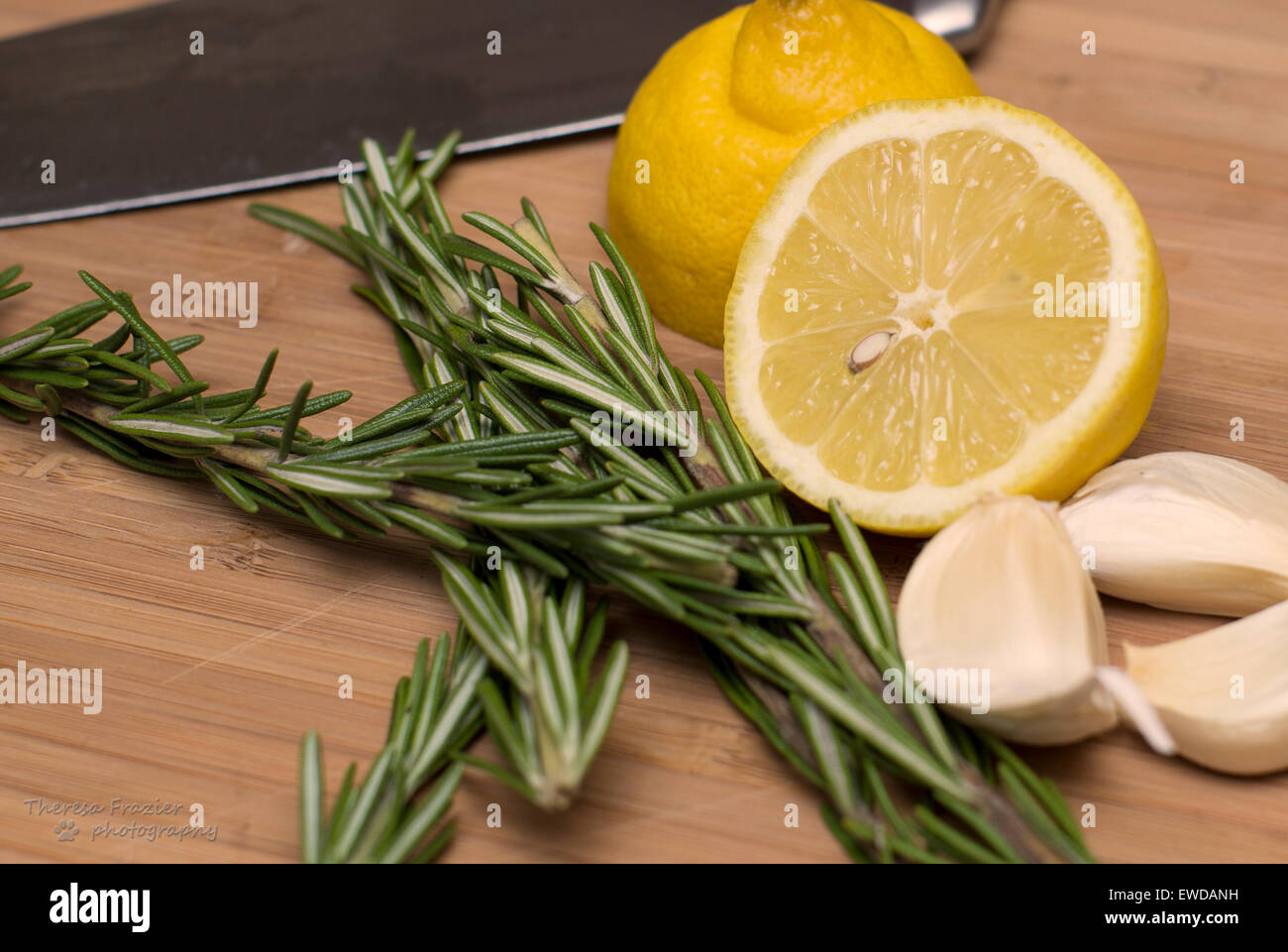 Limone, rosmarino e aglio su un tagliere pronto per la preparazione alimentare Foto Stock