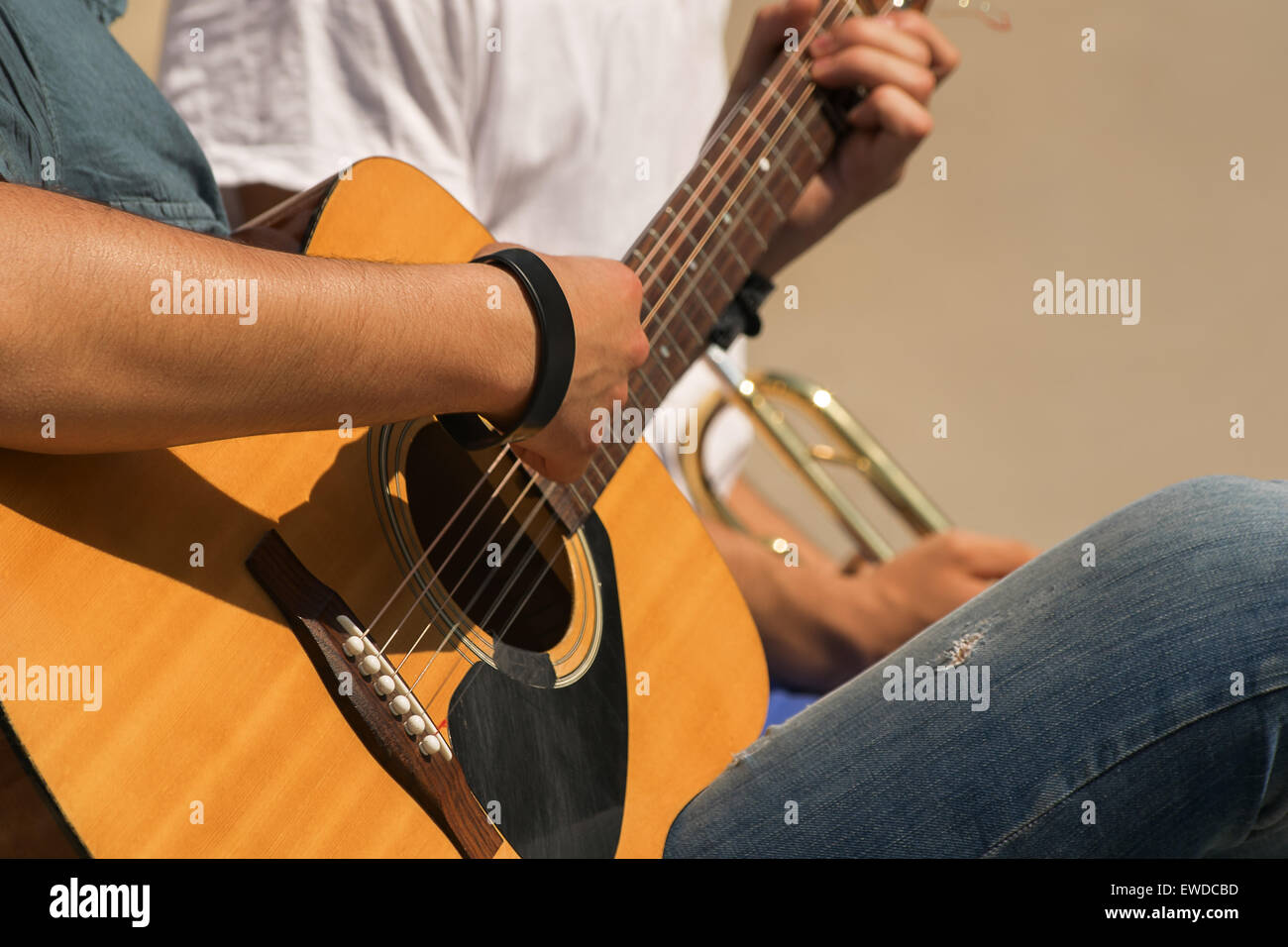 Close-up di un giovane di chitarra e tromba i giocatori che svolgono in una giornata di sole. Foto Stock