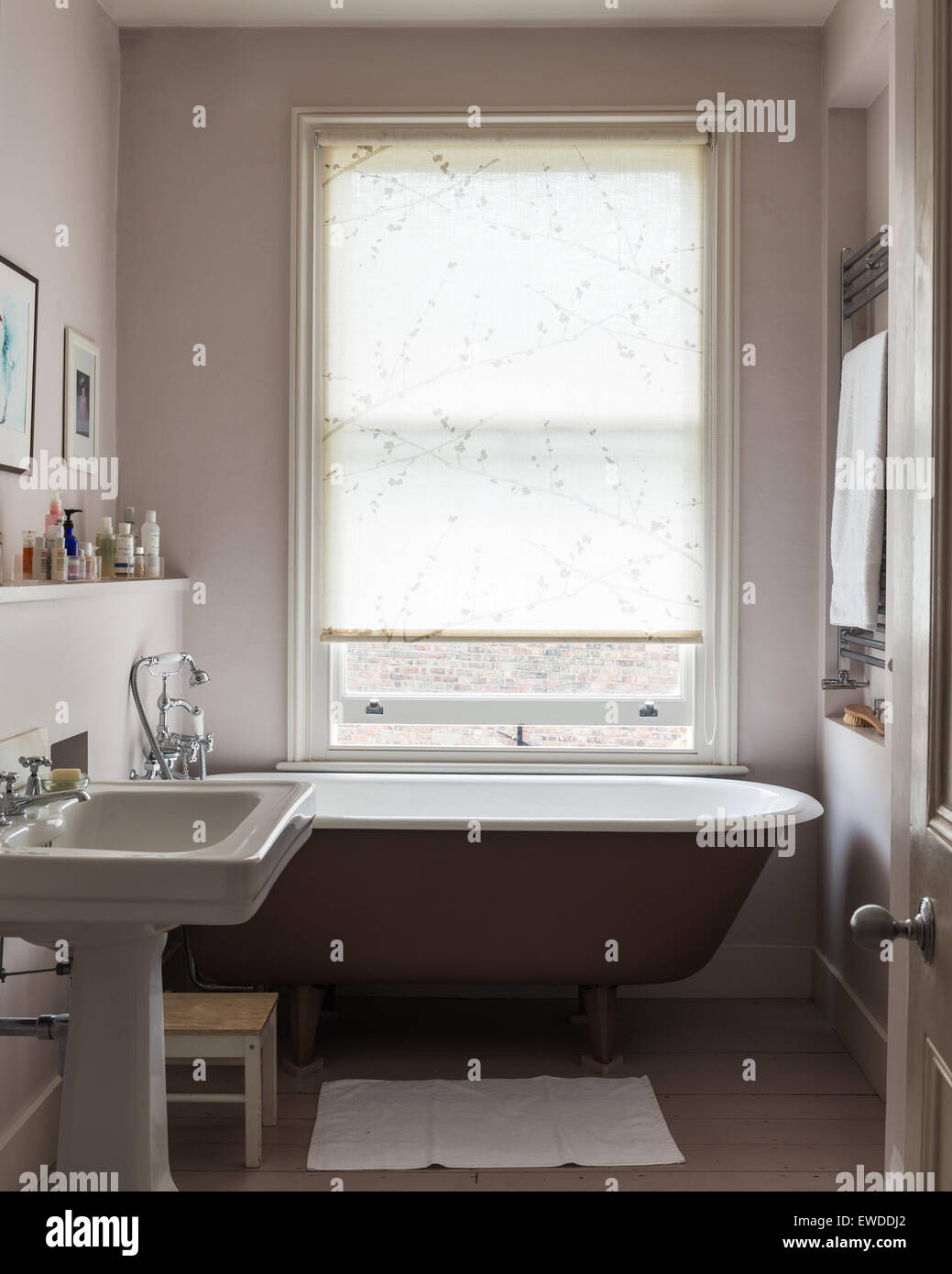 Free standing roll top vasca nella stanza da bagno con pavimento in legno e in stile vittoriano basin Foto Stock