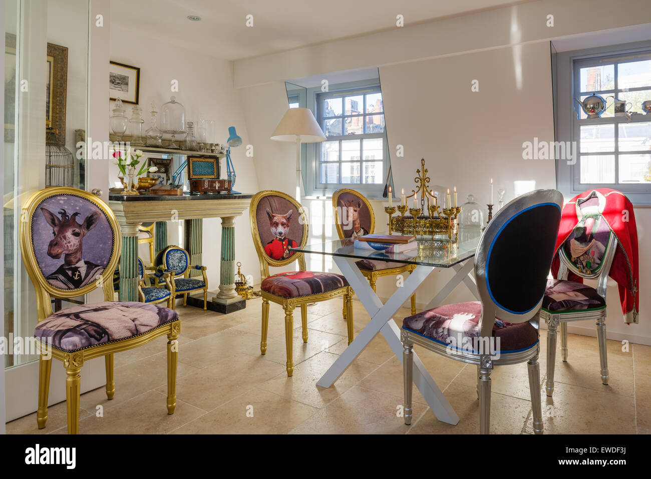 Sala da pranzo dorato sedie tappezzate in Cory di stampe Visitorian attorno al ripiano in vetro tavolo da pranzo Foto Stock