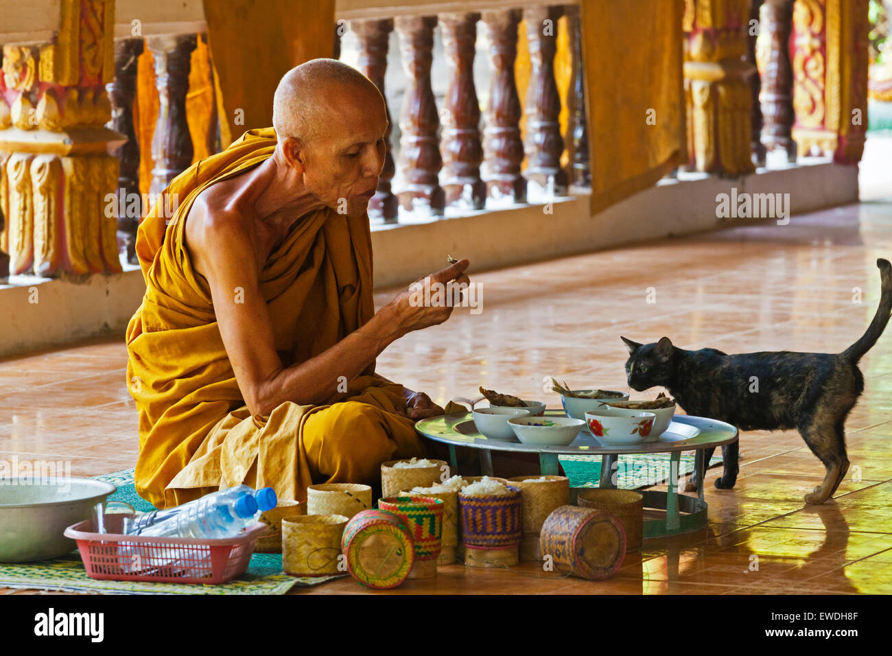 Un monaco buddista mangia il pranzo in un tempio su DON KHONG ISLAND in dieci mila isole area del fiume Mekong - Southern, LAOS Foto Stock